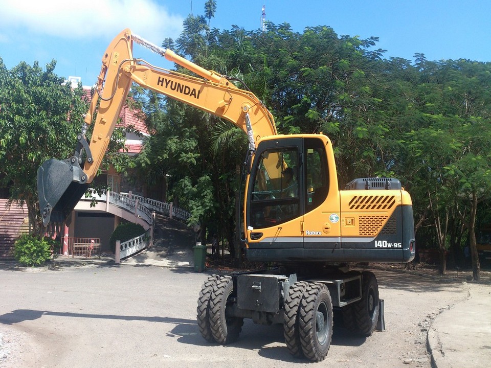 Xe xuc dao cho van hanh bai rac.jpg